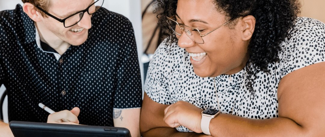 Two people smiling together during supportive mental health consultation.