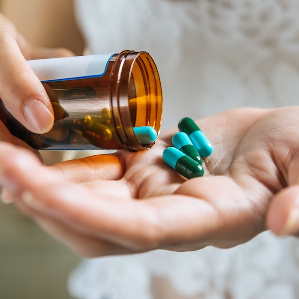 Photo illustration of person with medicine for the "Ask-A-Pharmacist" section of HealthyU at Nashville Cares.