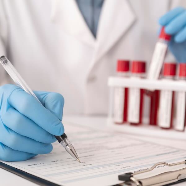 Photo illustration of lab worker recording medical information from test tubes..